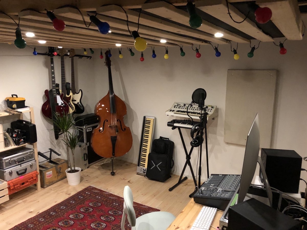 Indrettet studie hos en lejer med guitarer på væggen, kontrabas, synthesizere og kulørt lys