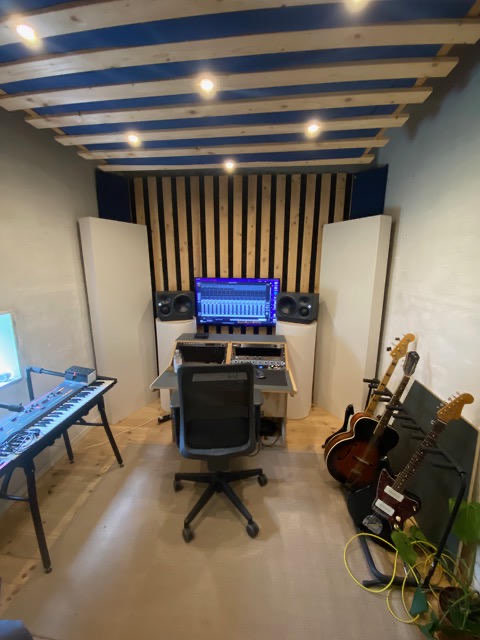 Indrettet produktionsstudie hos en lejer med studiemonitorer, keyboard og guitarer